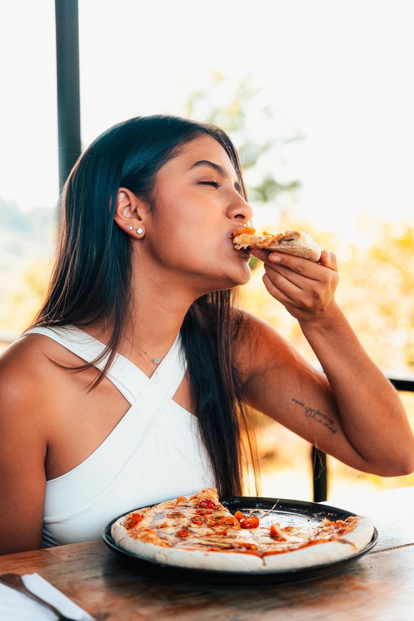 The Boato Hotel Guatapé Buitenkant foto A woman eating pizza